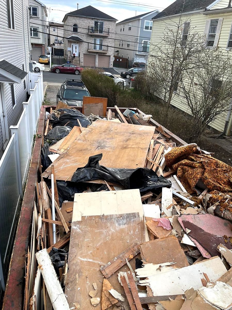 Front Range Waste & Roll-Off Services roll-off container delivery on residential driveway in Denver
